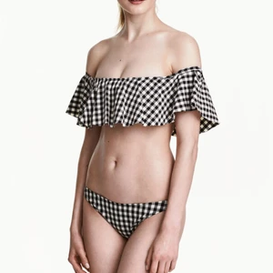 Bikini off shoulder - Svart och vit rutig bikini där toppen är off shoulder. Underdelen är rätt täckande. Köpt den i secondhand men själv aldrig använt den. Inköpt på hm I strlek 38 men lite liten I storleken