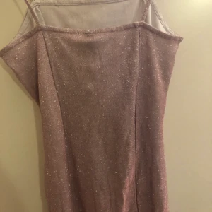 Glitterklänning - En mini glitterklänning med ett litet slitt på benet. Oanvänd med prisplatten fortfarande kvar. Nypris 150kr men jag säljer den för endast 50kr