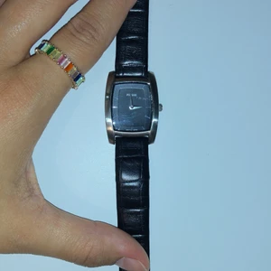 Klocka - Svart läder klocka, en mini nästan osynlig spricka. 