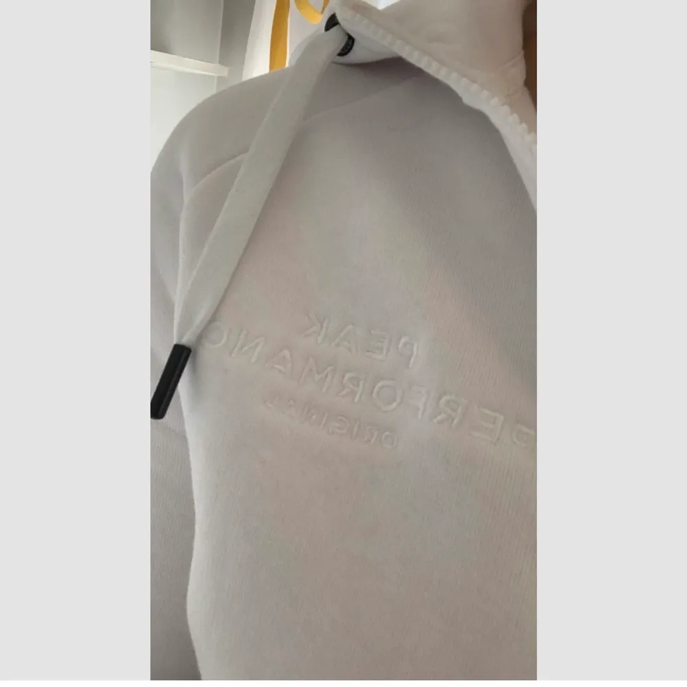Säljer denna vita zip hoodie från Peak Performance i otroligt bra skick, knappt använd. Säljer pga att den ej kommer till användning. Skriv gärna för fler bilder🥰  nypris 1200kr!. Hoodies.