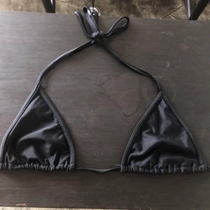 Svart bikinitopp - Helt vanlig svart bikinitopp med snören i nacken och på ryggen. Den är använd men ändå i fint sick. Jag tror att den är från stadium. Inte helt säker på hur mycket frakt kostar men det bör inte vara så mycket. Jag har även inläggen ifall man vill ha. Skriv för frågor eller bilder