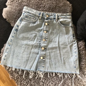 Jeans Kjol - En jeans kjol med många knappar som går att knäppa upp. Nyskick, enbart använd 1 gång. Ifrån H&M.