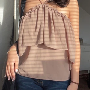 Jättesöt volang topp  - Drömmig volang topp från NA-KD i en beige färg. Går att ha på sig på två sätt (första och andra bilden). Har justerbara band. Storlek 38 men passar mig som har 36/38