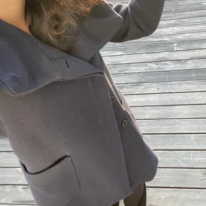 Marinblå vinterkappa - Marinblå vinterkappa från Zara i ull som inte passar  längre. Har en stor krage som kan användas som luva och två praktiska framfickor. I bra skick och söt kappa men passar inte mig längre som sagt. Skriv för fler bilder eller frågor