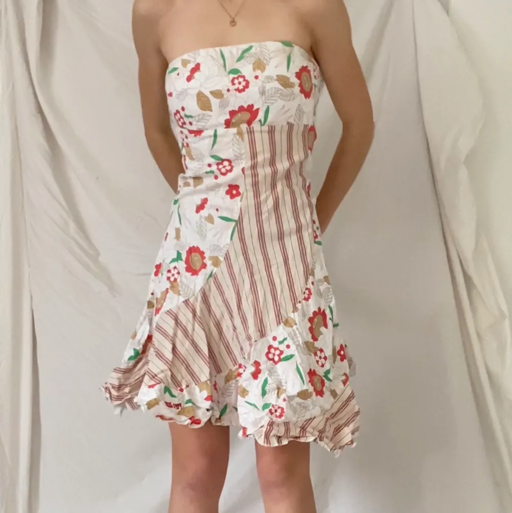 En cool tight klänning med blommönster och volangkjol. Sluter om kring kroppen bra. Lite skrynklig men fint skick!. Klänningar.