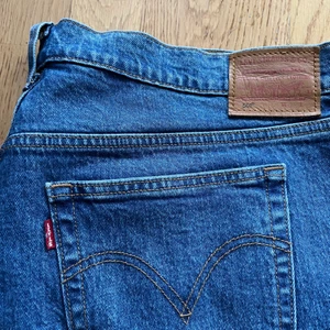 Levi’s 501, plussize  - Mellanblå Levi’s 501 i strl. 34”, stora i storleken, är från deras plus size avdelning. Ordinarie pris: 1099. Finns ett par klippta hål på insidan av linningen men ingenting som syns utifrån alls eller stör funktionen. Tyvärr blivit för stora för mig, därav säljes de. Fint skick, använda endast ett fåtal gånger. 