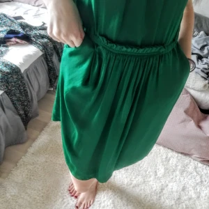 Klänning  - Vacker, smaragdgrön klänning med fickor från Zara. Står att den är xs men jag tycker den passar en 36 perfekt också. Material okänt, silkig lyster. 