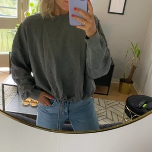 Grå tröja med dragsko - Grå tröja med dragsko i midjan från Bik Bok. Storlek XL. Sparsamt använd och i mycket bra skick.