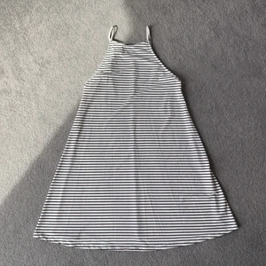 Vit klänning med svarta ränder stl S - Tunn och skön klänning i stl S, använd ett fåtal gånger.  Kort modell. Djur- och rökfritt hem