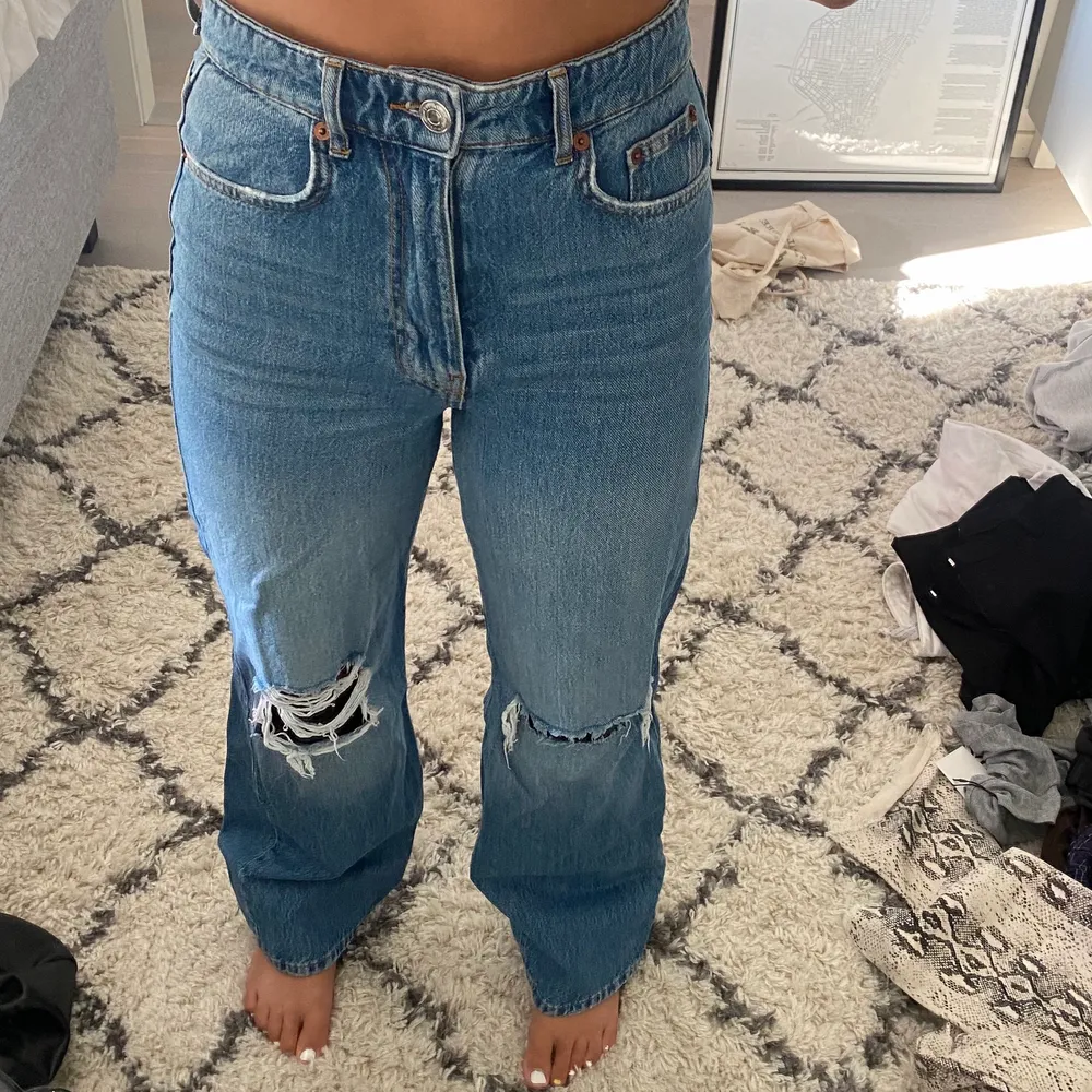 Mörkblå jeans med hål på knäna från Gina Tricot! Använda ett fåtal gånger, i bra skick förutom en slitning längst ner på höger ben. Frakt tillkommer, storleken är 34 men passar 36. Jeans & Byxor.