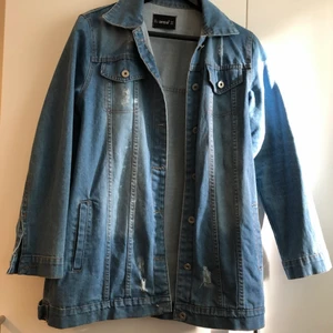 Jeansjacka - Längre jeansjacka med lite slitningar som detaljer, jätte bra skick bara använd två gånger, det står storlek L men skulle säga att det är M Säljer då den inte passar längre