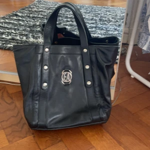 Svart Armani väska  - Väska i svart skin från Emporio Armani. Tillverkad i Italien. (Fodret inuti väskan har blivit lite fläckigt pga en necessär som spilldes.) Väskan är äkta och annars sparsamt använd<3 skriv om du är intresserad och vad du vill köpa den för!
