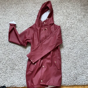 Regnkappa  - Vinröd regnkappa. Aldrig använd.