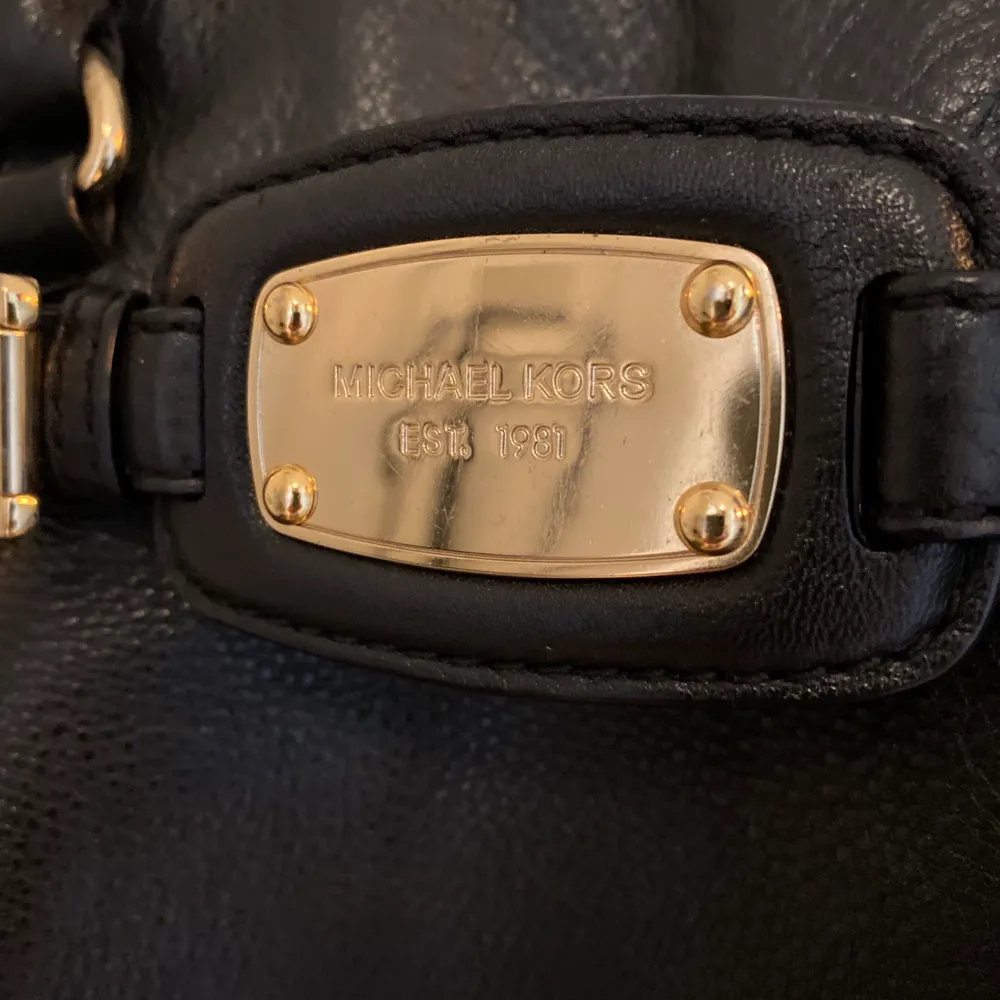 Svart handväska med gulddetaljer från Michael Kors. Köpt i USA 2013 och inte använd sedan 2015, så den är i väldigt gott skick! Inga synliga skador och skinnet är väl omhändertaget. Plats för A4-block och/eller laptop finns! . Väskor.