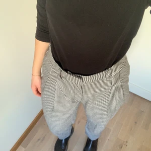 Houndstooth print straight leg trousers. - Relaxed straight leg trousers with black and white houndstooth print. The waist is elastic and stretches a lot. The pants have two pockets in the front (no pocket in the back, it is only decorative). The fit is very relaxed. Although they are a size 38, the fit more like a size 40, and as seen on the pictures they fit quite baggy.