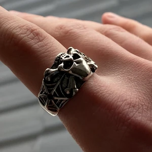 Dödskalle ring - En fin dödskalle ring med spindelnät om sidorna. Ring som rostar tyvärr men kan lackeras så rostas den ej! Annars helt oanvänd, köp nu! Frakt är 13 kr :)