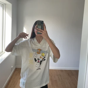 Oversized looney tunes t-shirt  - En ovetsized t-shirt med tryck på både fram och baksida. Tröjan är i nyskick (använd en gång förra sommaren). Tröjan är beige med tryck som har pastell färger.