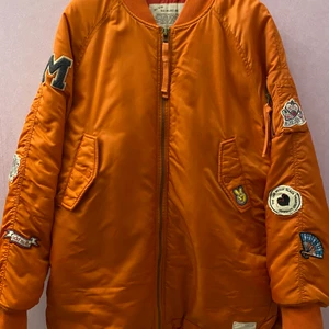 Odd Molly - Love Bomber Jacket - Stl 4 *NY* - Jacka Love Bomber från Odd Molly är en lång, dun vadderad bomberjacka med ribbmudd i hals och ärmslut samt tvåvägsdragkedja och två fickor med ficklock och tryckknapp fram. Rundade sidor med sprund nedtill. Dekorativa applikationer på ärmarna och framfickan. Dragkedjeficka på ena ärmen samt Odd Molly-mynt i nacken. Kontrastfärgat, mönstrat foder. En innerficka. Längd 76 cm i stl M.  Utförande: Vävt Fyllning: 100% Polyester Passform: Regular Foder: 100% Polyester Yttertyg: 100% Polyamid Aldrig använd, nypris 2500:-, kan självklart skickas med postens skicka lätt. Swish finns!