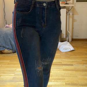 Blå jeans med röda detaljer på sidorna🧸 har även små hål vi knäna/ låren🧸