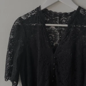 Svart spetsklänning - En svart långklänning i spets. Fina detaljer med knyte i midjan. Går ned till vaderna. Storlek: S/M