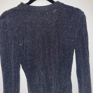 Glittrig svart body - Svart glittrig body från H&M. Har använt den ungefär 2-3 gånger och säljer den för att jag ej använder den längre. Jättefin att ha på fest med svarta byxor eller en svart kjol❣️