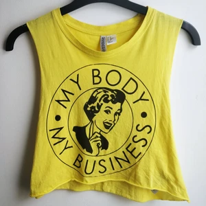 Crop top - Gul crop top/magtröja med tryck av the Girl Collective. Går både bra att bära löst (XS) eller tightare om man har större storlek. I princip oanvänd! 