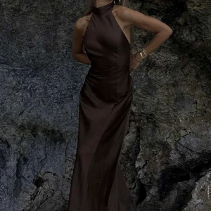 Maxiklänning - Brun Maxiklänning från Hanna Schönbergs kollektion med NA-KD. Limited edition och går inte att få tag på. Aldrig använd. Storlek 32, men passar en 34🤎 köparen står för frakten:)