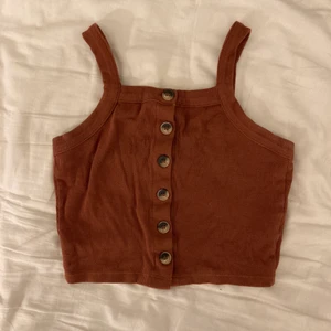 brun topp med knappar - Brunt välanvänd topp från monki. Fina knappar och stretchiga typ!