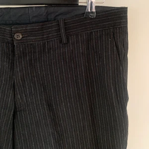 Randiga kostymbyxor - Brun och grå randiga kostymbyxor. Lite utsvängda vid vaden. Sitter lågmidjat på höfterna på mig (S/M)