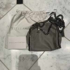 Stella McCartney falabella shoulder bag - 💀INTRESSEKOLL💀 På min jättesnygga gråa StellamcCartney väska som tyvärr inte kommer till användning! Den är i storleken tiny⚡️ Jag köpte den i augusti på miinto. Den har ett nypris på 6000🛍Den är sparsamt använd och har inga defekter! 💘 Dustbag och äktahetsbevis ingår⭐️Hör av dig om du är intresserad (endast för seriösa)🎸 köparen står för frakten! 😊 Hör av dig i DM om du har några frågor och behöver fler bilder på väskan!!🤘🏼Det är många intresserade❤️ köp direkt för 3500🙌🏻 