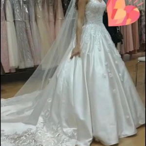 Brudklänning (Fortfarande prislapp på) - säljer brudklänning som är helt oanvänd. Prislapp finns fortfarande kvar.  Det som är ingår: slöja, underkjol  Silkematerial på klänningen.  Storlek, 34-36. Nyköpspris 19 000 kr.  Mitt pris: 9 000 kr. Kan även hämtas Helsingborg och Ängelholm. Axelband är ditsatta av en sömmerska, därför är de utan axelband på två av bilderna. Skriv vid frågor.