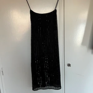 Svart paljettklänning  - Svart paljettklänning från Gina med korsade band i ryggen, perfekt till fest med typ 20-talstema! Stl 34, tts. Några paljetter/pärlor kan ha lossnat men annars superfint skick 🖤116 kr inkl spårbar frakt