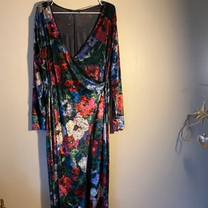 En vadlång omlott klänning  - En vadlång blommig omlott klänning ifrån Zara. Klänningen går att öppna upp helt. Materialet på klänningen påminner om siden 