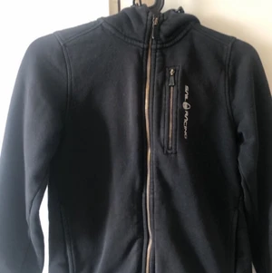 Svart sail racing kofta  - Säljer en svart sail racing kofta. I storlek 150. Köpt för 900kr och säljer för 300kr+ frakt🤍 Inga skador eller så bara vid dragkedjorna så är det svarta lite bort skrapas som man kan se på första bilden, men det är knappt något som syns🤍 om man vill ha fler bilder så är det bara att höra av sig🤍