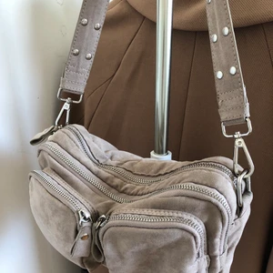 Väska i mockaimitation - Väska i mockaimitation från ginatricot. Fint skick bortsett från en liten defekt på bandet (se bild 3), denna kan dock lätt bytas ut. 