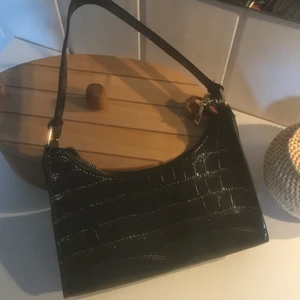 svart axelväska - svart axelväska i glansigt krokodilmönster. guldiga detaljer. köpt på shein, aldrig använd. köparen står för frakten✨