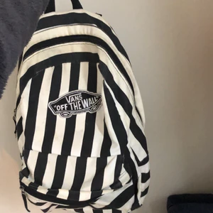 Svartvit, randig vans ryggsäck.  - En ryggsäck från märket Vans. Svartvit och randig ryggsäck med ett stort och ett litet fack. 
