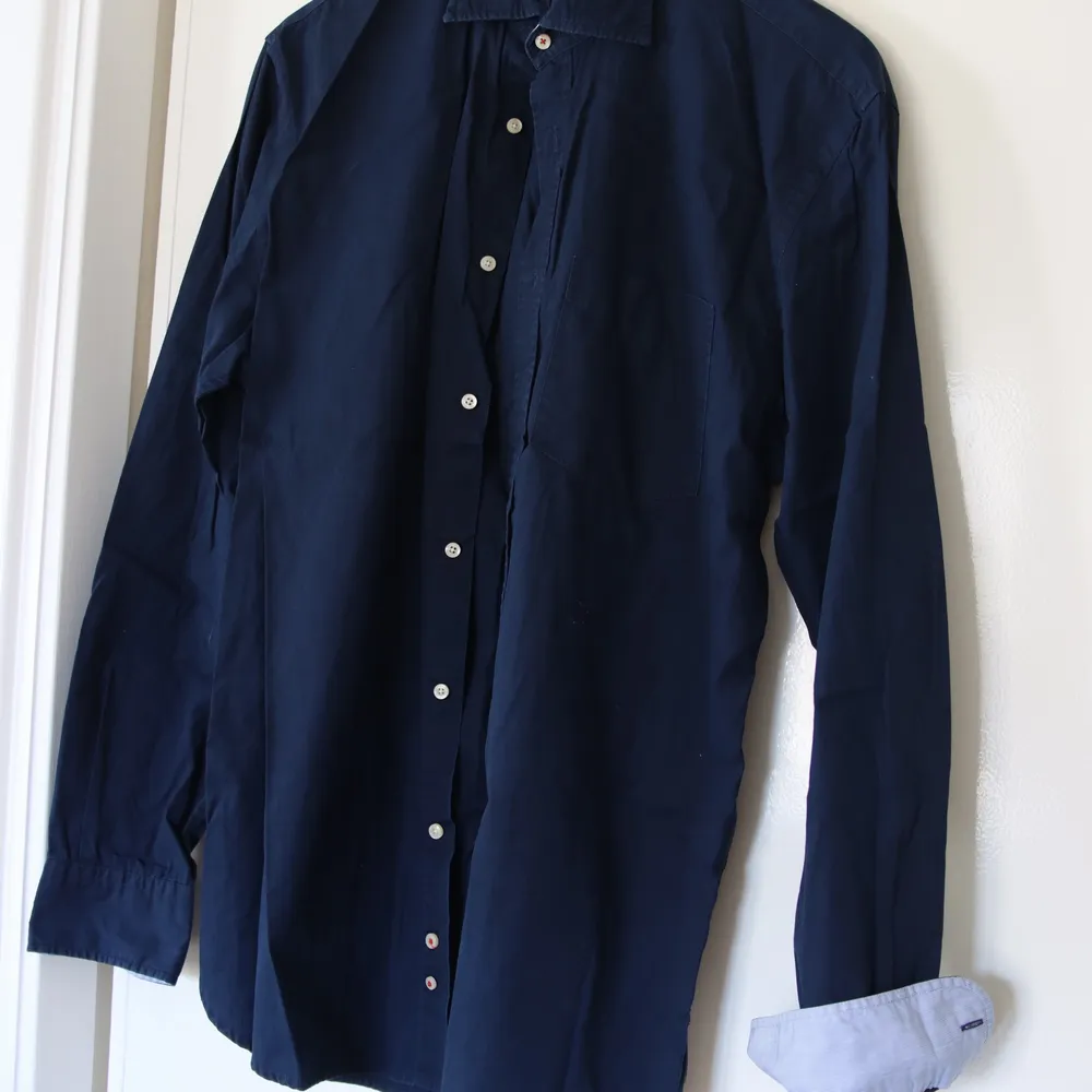 Snygg marinblå skjorta i fin italiensk bomull från brittiska Hackett. En favorit året om! Cutaway-krage och smal passform. Upplevs som en stor medium. . Skjortor.