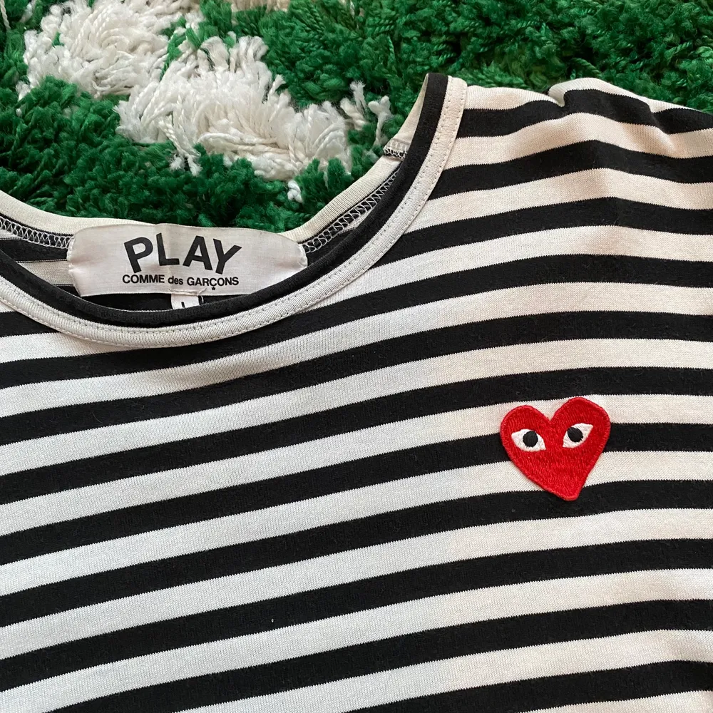 Randig comme des garçons-tröja i strl L (man), men liten i storleken. Perfekt oversize på mig som vanligtvis bär 38/40 :) Tre små hål längst ner på tröjan, se tredje bilden. Därav bra pris! Utöver det väldigt bra skick och sparsamt använd, hålen syns knappt med tröjan på eller instoppad i brallorna. Kontakta mig gärna om det är nåt mer du undrar :). Yläosat.