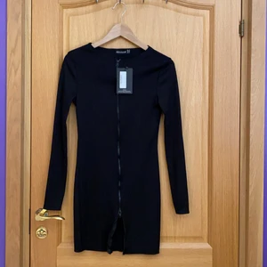 Prettylittle thing klänning i storlek 34 - En svart snygg klänning med dragkedja hela vägen ned. Styla den hur du vill. Klänningen är helt oanvänd men lappen kvar på. Klänningen är i storlek 34. 