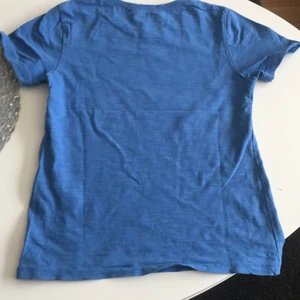 En blå tröja  - En blå tommy och Jerry tröja har änvänts några gånger och är bra skick.