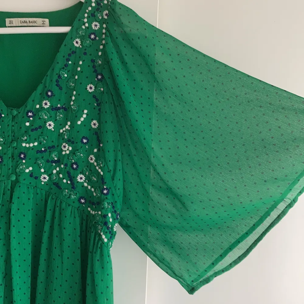 Grön klänning med inbyggda shorts (syns inte pga allt tyg) med söt dekor och små prickar. Använd en gång. Skön och tunn i materialet. Bilden gör inte klänningen rättvis, den är grönare irl. . Klänningar.