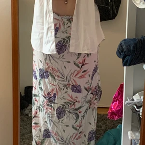 Hm lång blommig kjol - Använts ca3 ggr. Älskar den men passar nt min stil. Har en slits på sidan och en vit kort underkjol. Frakt ingår inte! Går att använda som både högmidjad och lågmidjad.