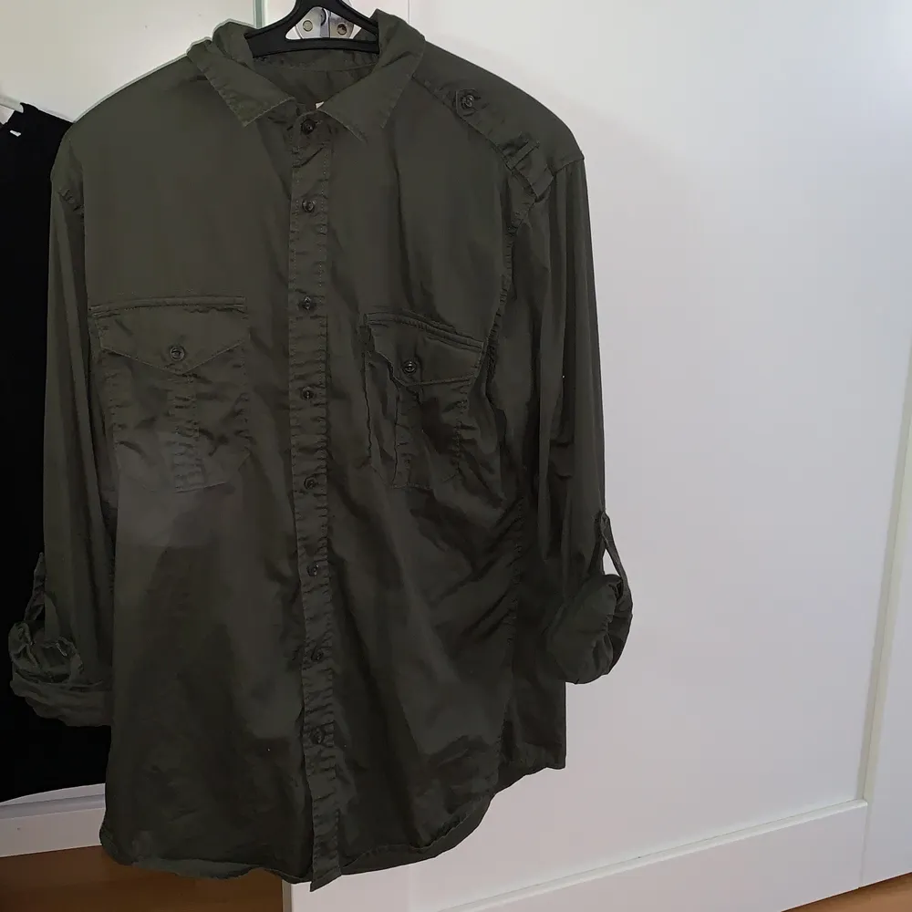 En skjorta i militärgrön aktig färg från Dressman. Använd några gånger men är i fint skick. Denna är i storlek M och är Slim fit modell.. Skjortor.