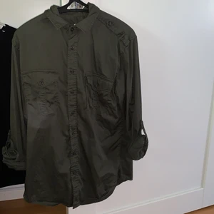 Skjorta - En skjorta i militärgrön aktig färg från Dressman. Använd några gånger men är i fint skick. Denna är i storlek M och är Slim fit modell.