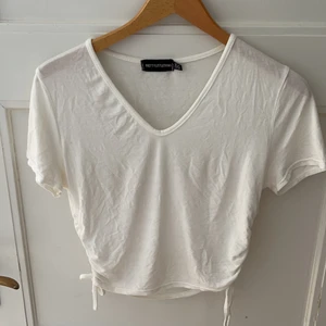 Vit topp - Söt topp från Pretty Little Thing. Har knytningar i sidan. Säljs för att den helt enkelt aldrig används. 