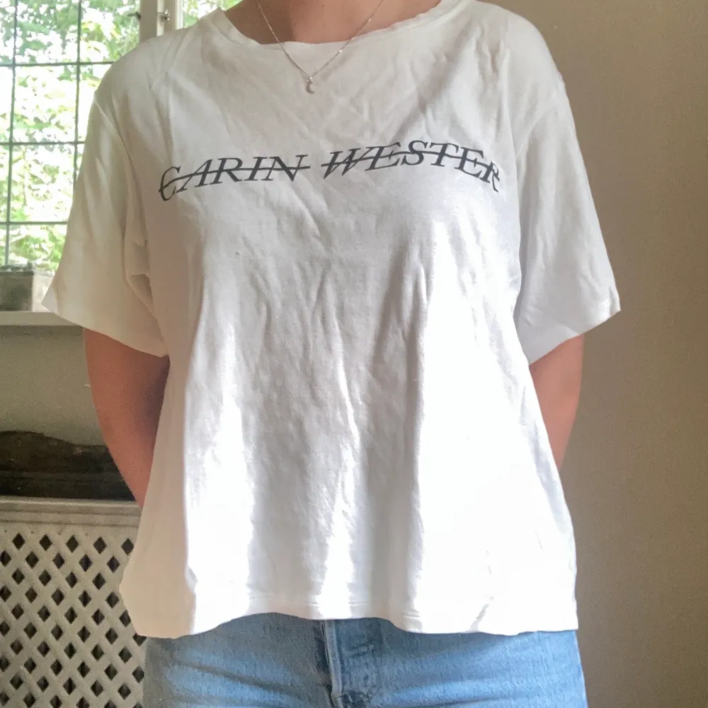 Vit t-shirt med tryck från Carin Wester. Knappt använd. Storlek: M Material: 100% bomull. T-shirts.