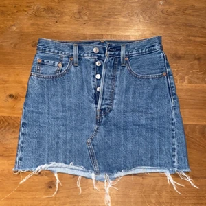 Levis jeans kjol - Levis jeanskjol, flera knappar och fransar där nere.mycket fint skick! Nypris 599kr. mitt pris 300kr. (Pris kan förhandlas)
