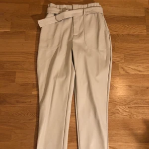 Skinnbyxor fake beiga oanvända - Fake skinnbyxor i beige med avtagbart bälte, oanvända i 38