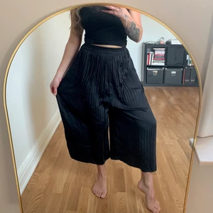 Cropped pants, plisserade byxor från ZARA - Svarta ”croppade” byxor från ZARA i storlek S. Plisserade i glansigt satin-tyg. Otroligt sköna och lätta, resår i midjan. Oanvända. Köparen står för frakten som tillkommer 💌